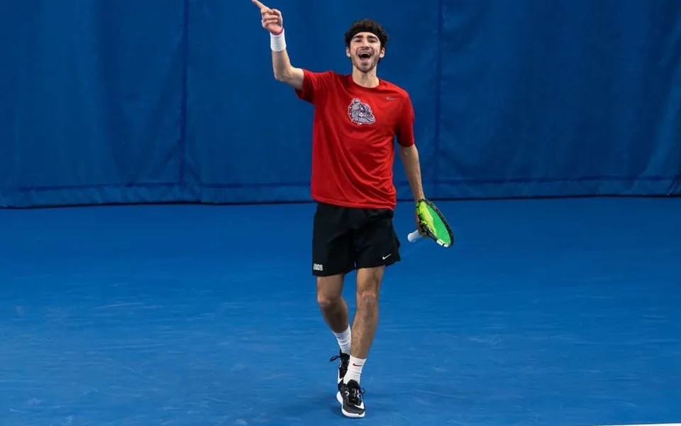 Oscar pointing to the crowd and celebrating on court in a Gonzaga shirt